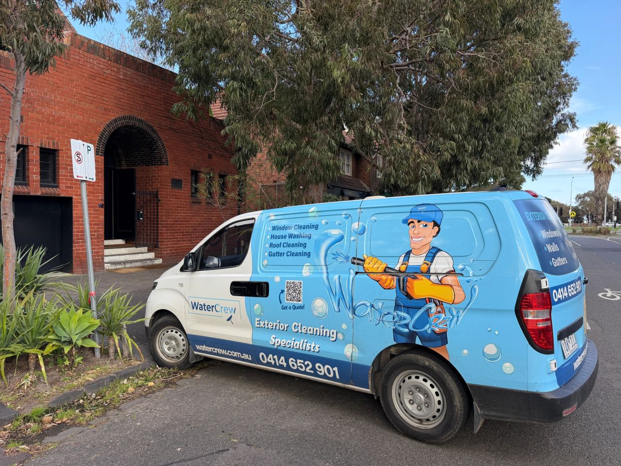 Signwritten WaterCrew van parked outside a red-brick apartment block in St Kilda West