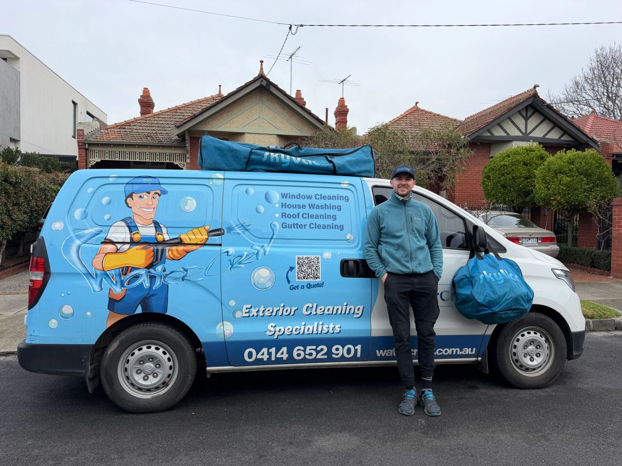 WaterCrew technician beside the van with SkyVac gutter vacuum kit on an Elsternwick street