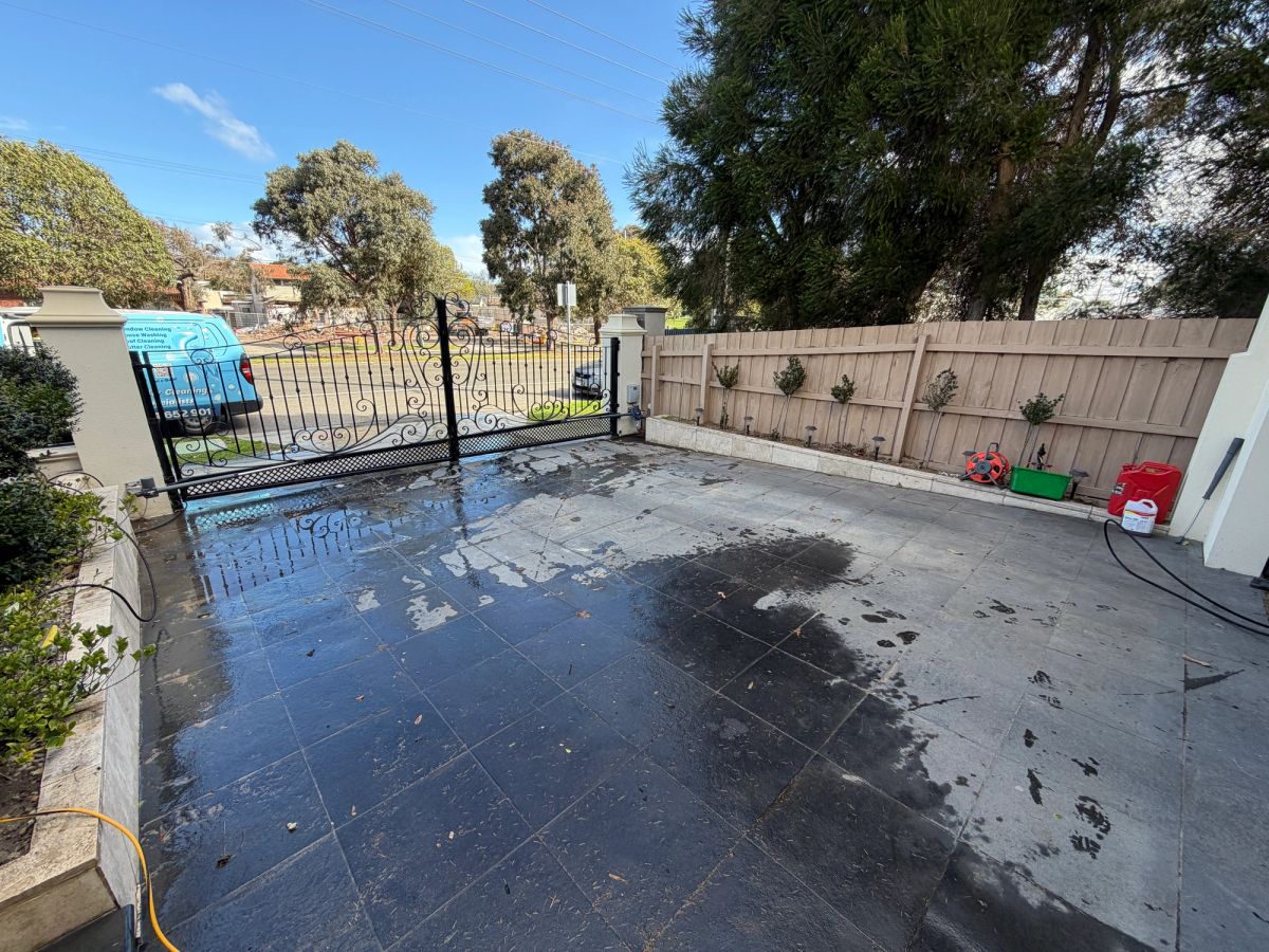 Charcoal bluestone driveway on South Road blotched with pale film before cleaning