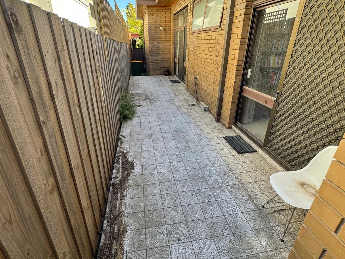 Heavily soiled backyard paving on Alston Grove before cleaning, surface darkened by organic growth