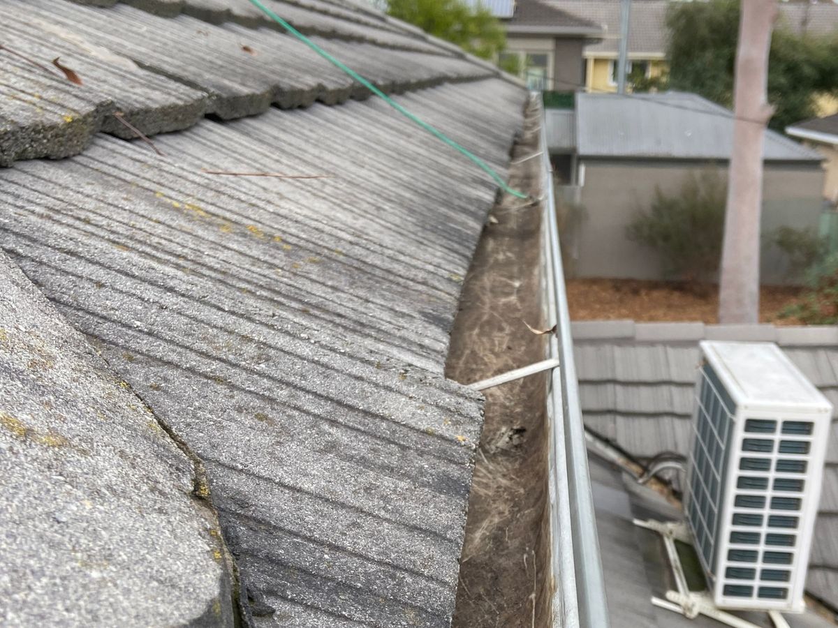 The same Bluff Road gutter cleared to the metal, with the grit layer removed