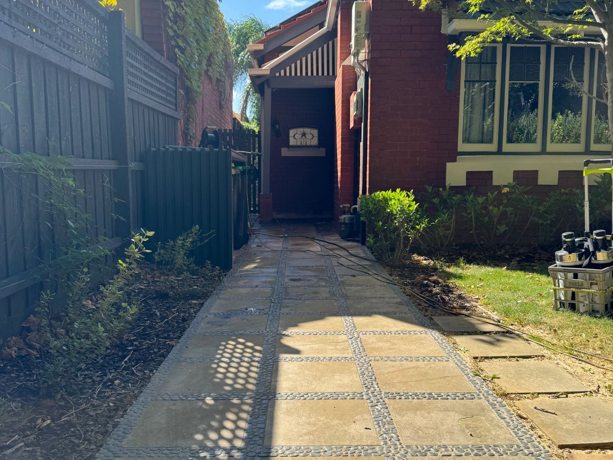 Driveway on Ruskin Street, Elwood with oil staining and growth in the centre strip before cleaning