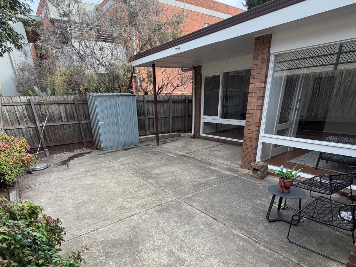 Concrete on Hotham Street, St Kilda East darkened by algae and lichen before cleaning