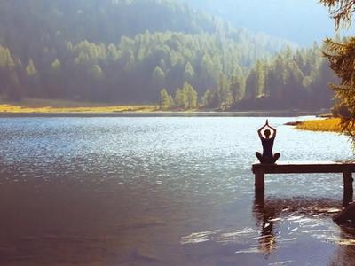 Person meditating peacefully by a mountain lake - representing calm mind, emotional balance, and stress relief through functional medicine treatment for anxiety in Denver, Colorado Springs, and Fort Collins