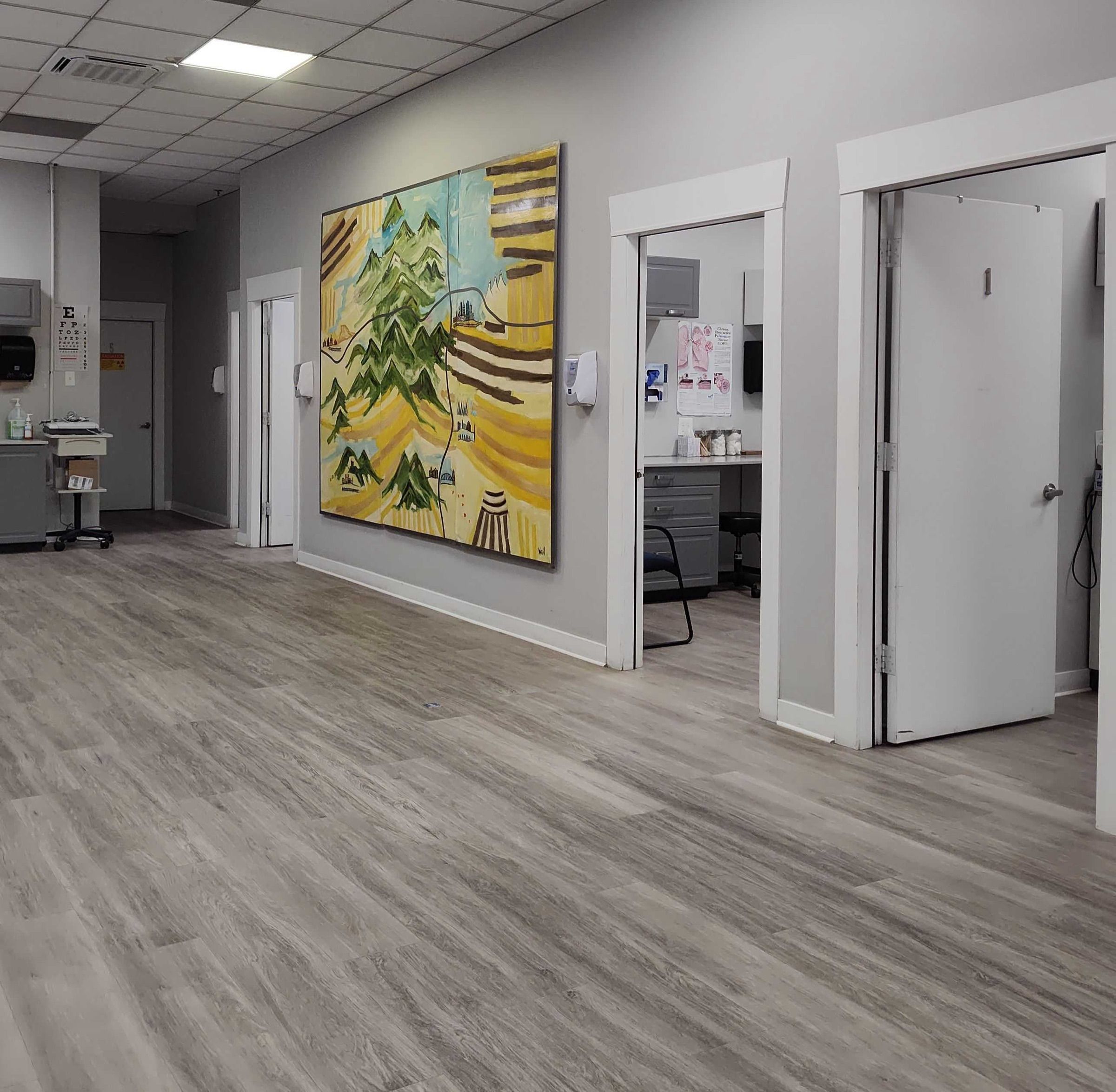 Hallway with colorful artwork and exam rooms