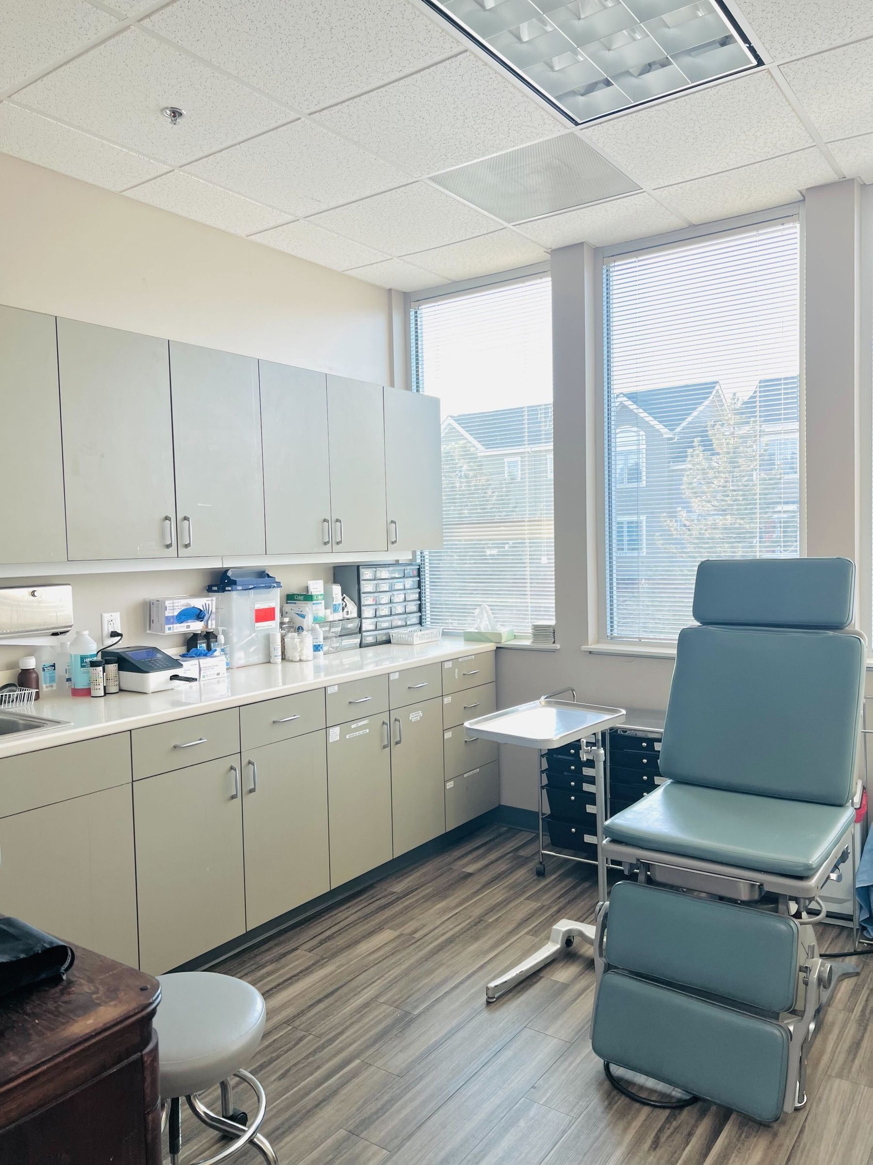 Bright exam room with an exam chair and supply cabinets