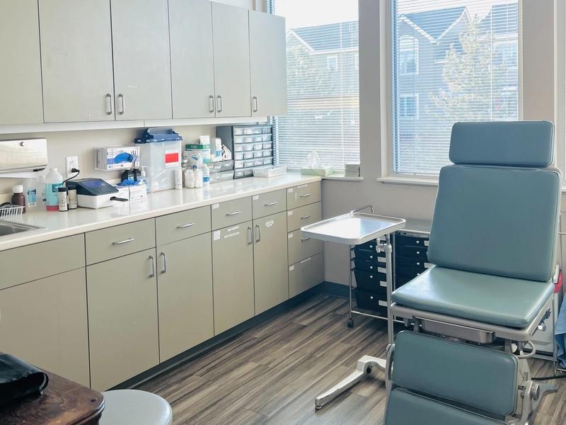 Bright exam room with an exam chair and supply cabinets