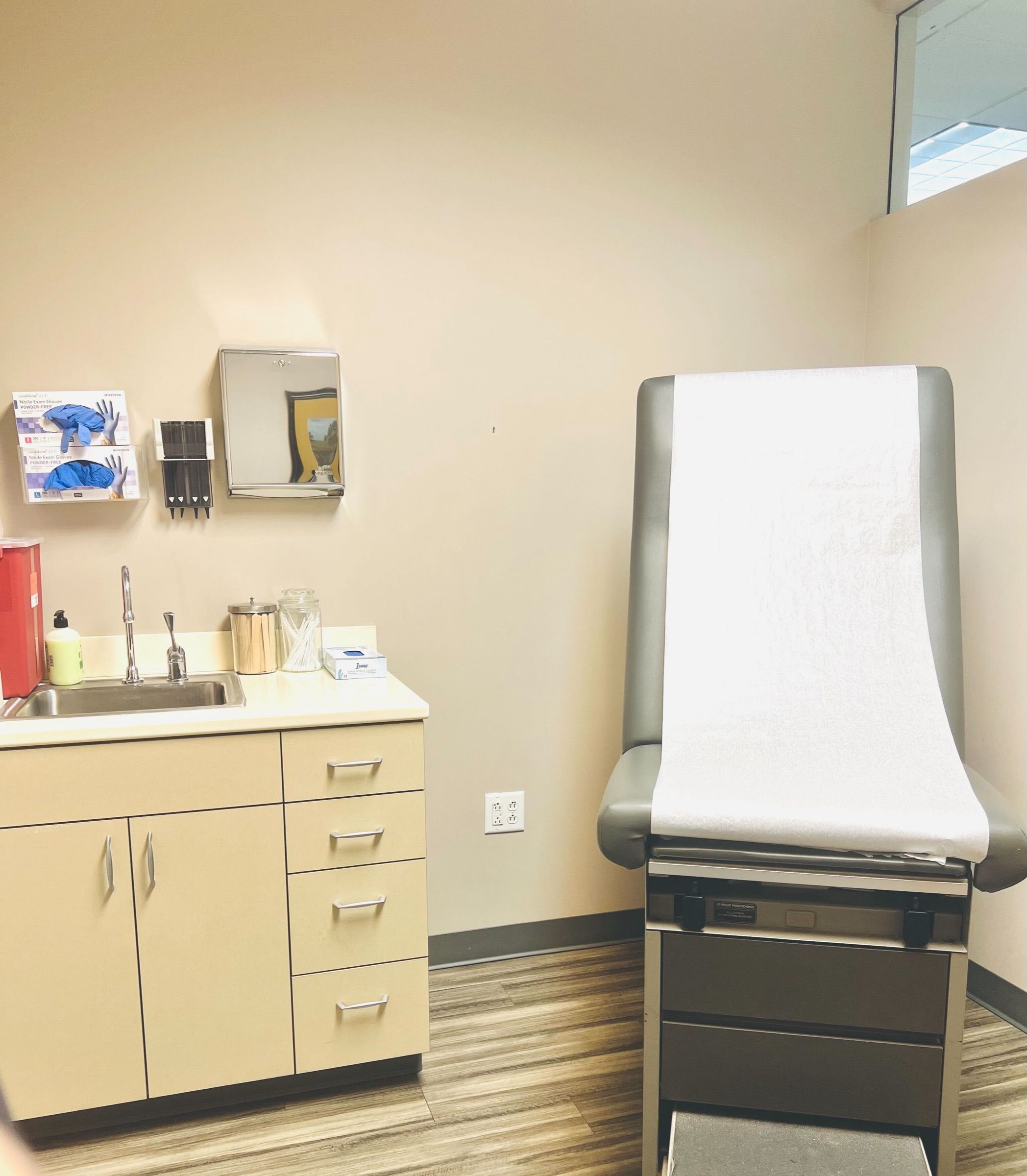 Exam room with an exam table, sink and cabinets