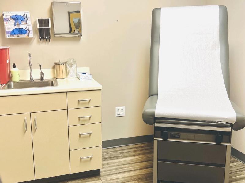 Exam room with an exam table, sink and cabinets