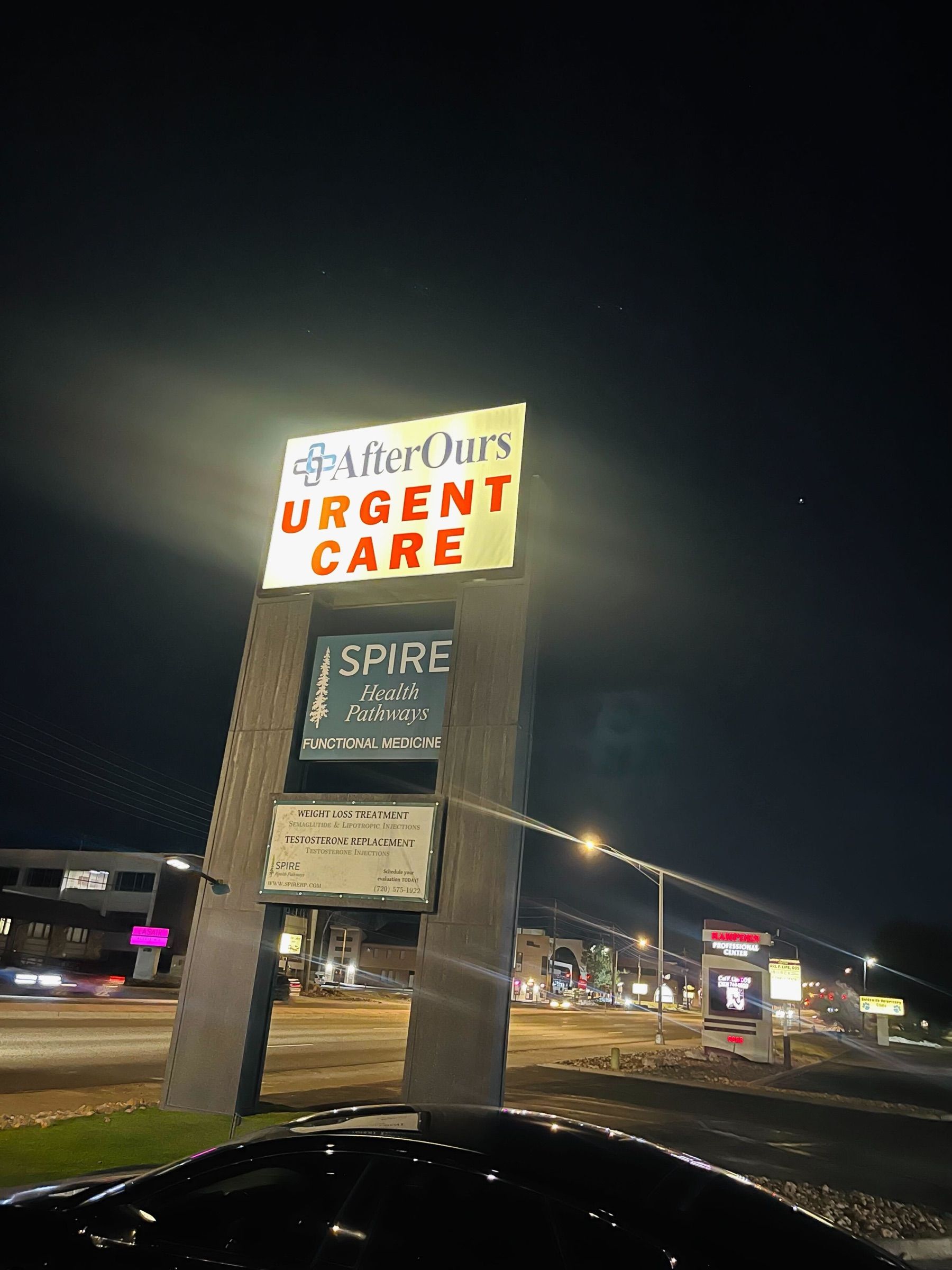 Illuminated AfterOurs Urgent Care sign at night