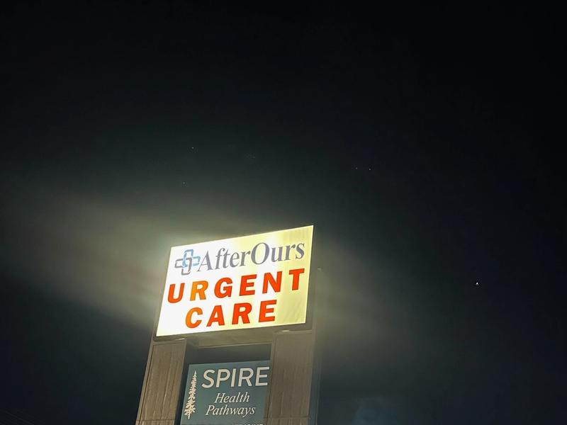 Illuminated AfterOurs Urgent Care sign at night