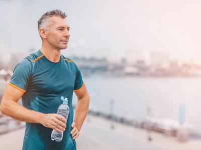 Man standing outdoors with a water bottle, looking strong and focused - representing adrenal health, hormone balance, and recovery through functional medicine treatment for Addison's disease in Denver, Colorado Springs, and Fort Collins