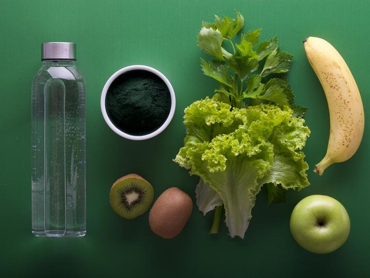 Nutritious fruits and veggies with a bottle of water focusing on improving one's gut health
