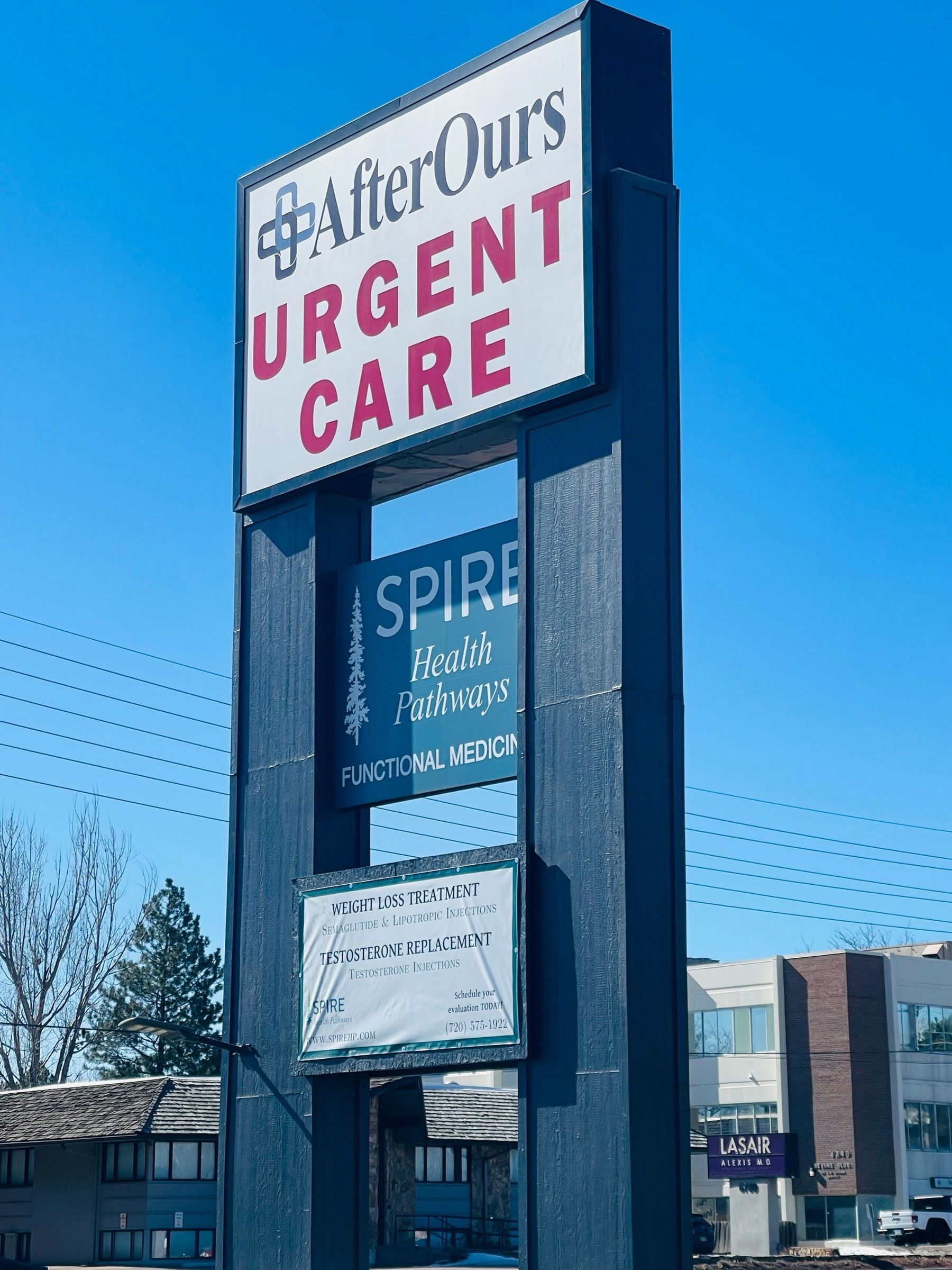 AfterOurs Urgent Care roadside sign against a blue sky