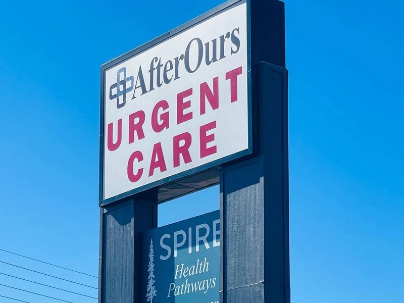 AfterOurs Urgent Care roadside sign against a blue sky