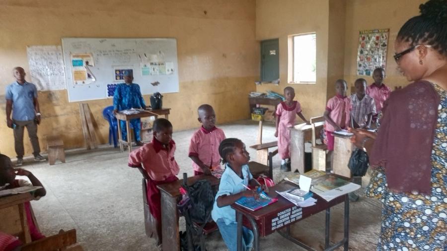 A teacher and pupils in a classroom during the notebook distribution