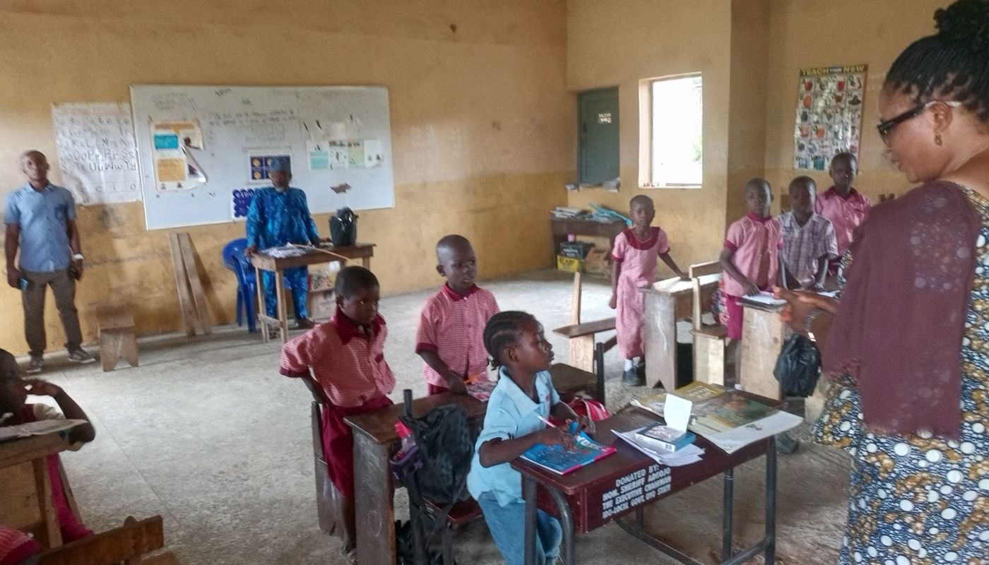 A teacher and pupils in a classroom during the notebook distribution
