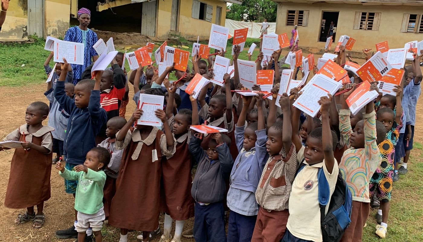 Pupils in Oyo State holding up their new notebooks