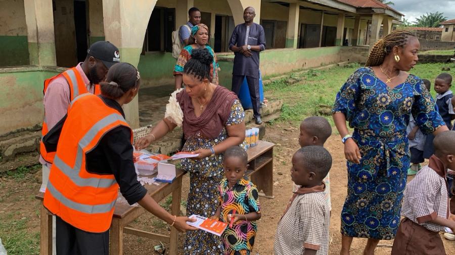 Foundation volunteers handing out notebooks to pupils