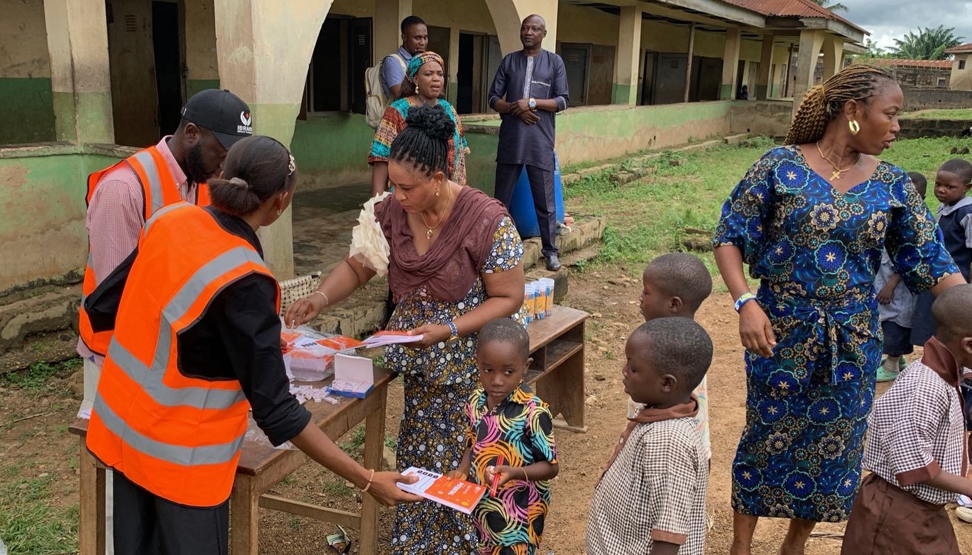 Foundation volunteers handing out notebooks to pupils
