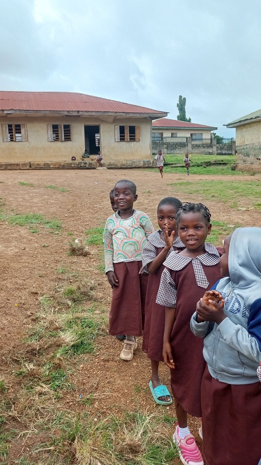 Three pupils in maroon uniforms smiling