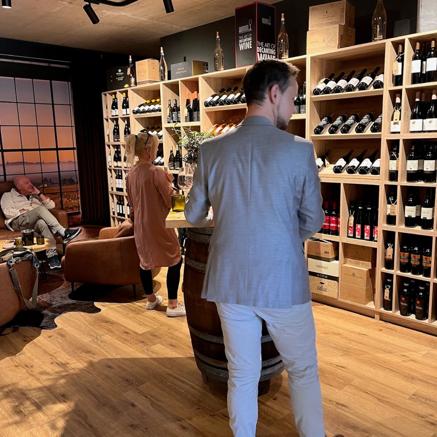 In der Vinothek vor den Weinregalen bei der Weinprobe