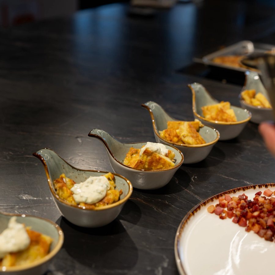 Amuse-Bouche auf Löffeln, frisch angerichtet in der Liveküche