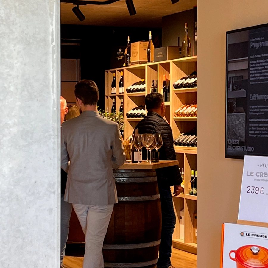 Weinauswahl am Vinothek-Regal mit Weinfass im Thoki Studio