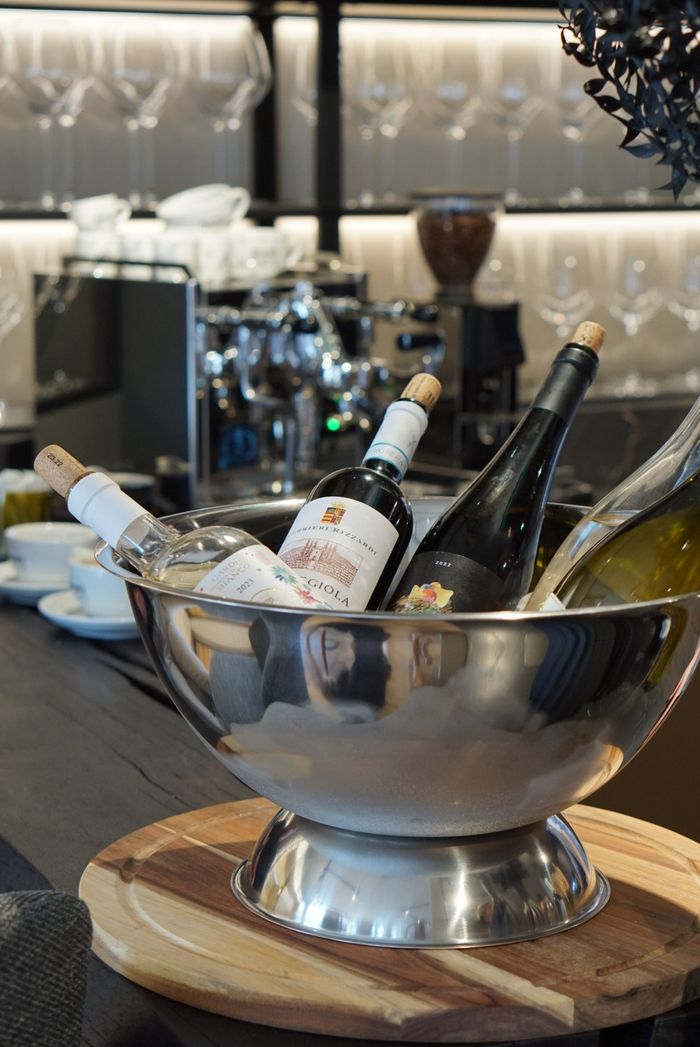 Weinflaschen und Champagnerschale in der Thoki Vinothek