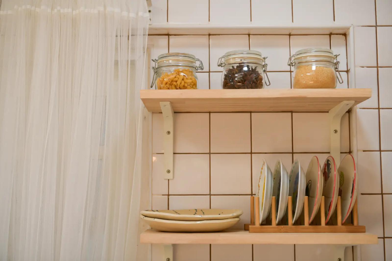 9️⃣ Offene Küchenregale mit Gläsern und Tellern: platzsparende Küchenorganisationstipps für Geschirraufbewahrung.