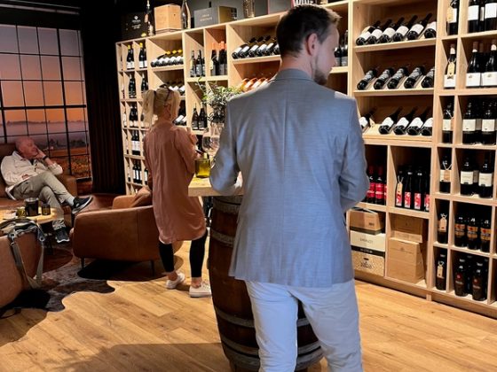 In der Vinothek vor den Weinregalen bei der Weinprobe