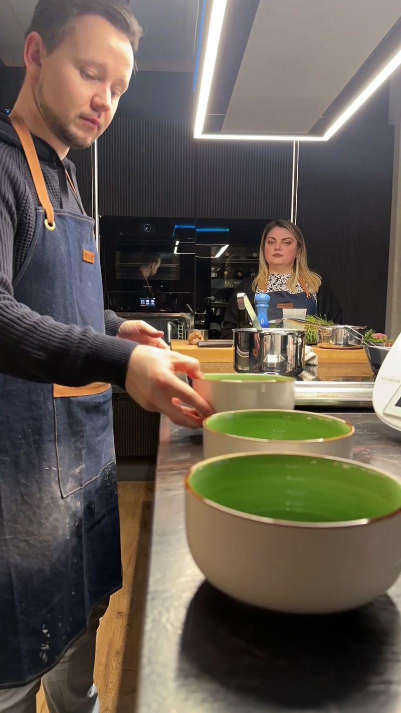 Liveküche im Studio Wörthsee: Thomas richtet Schalen an, Eugenia am Kochfeld