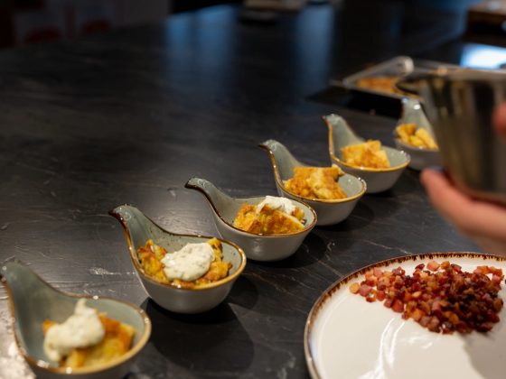 Amuse-Bouche auf Löffeln, frisch angerichtet in der Liveküche