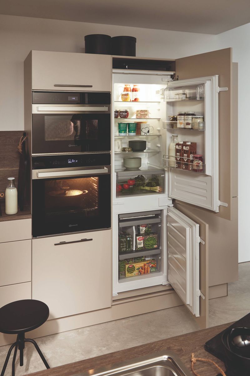 Moderne Thoki Einbauküche mit integriertem Kühlschrank, Gefrierschrank und Backofen in beigefarbenen Fronten