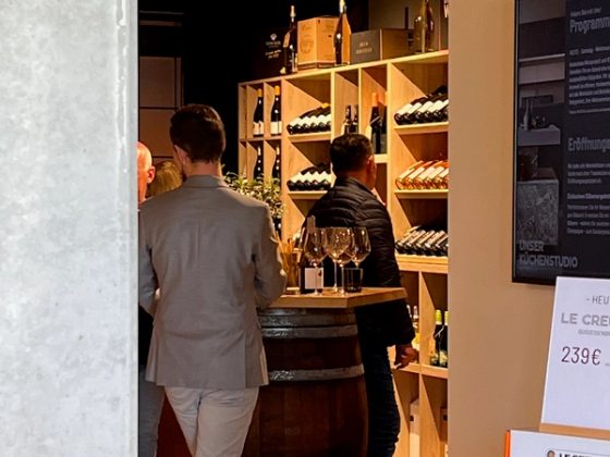 Weinauswahl am Vinothek-Regal mit Weinfass im Thoki Studio