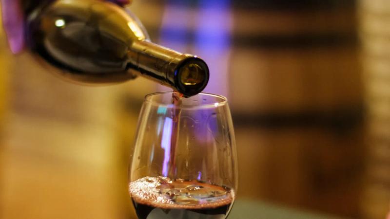 Rotwein wird aus Flasche in Glas eingeschenkt: Wein-Lifehack von Thoki Küchenstudio Wörthsee
