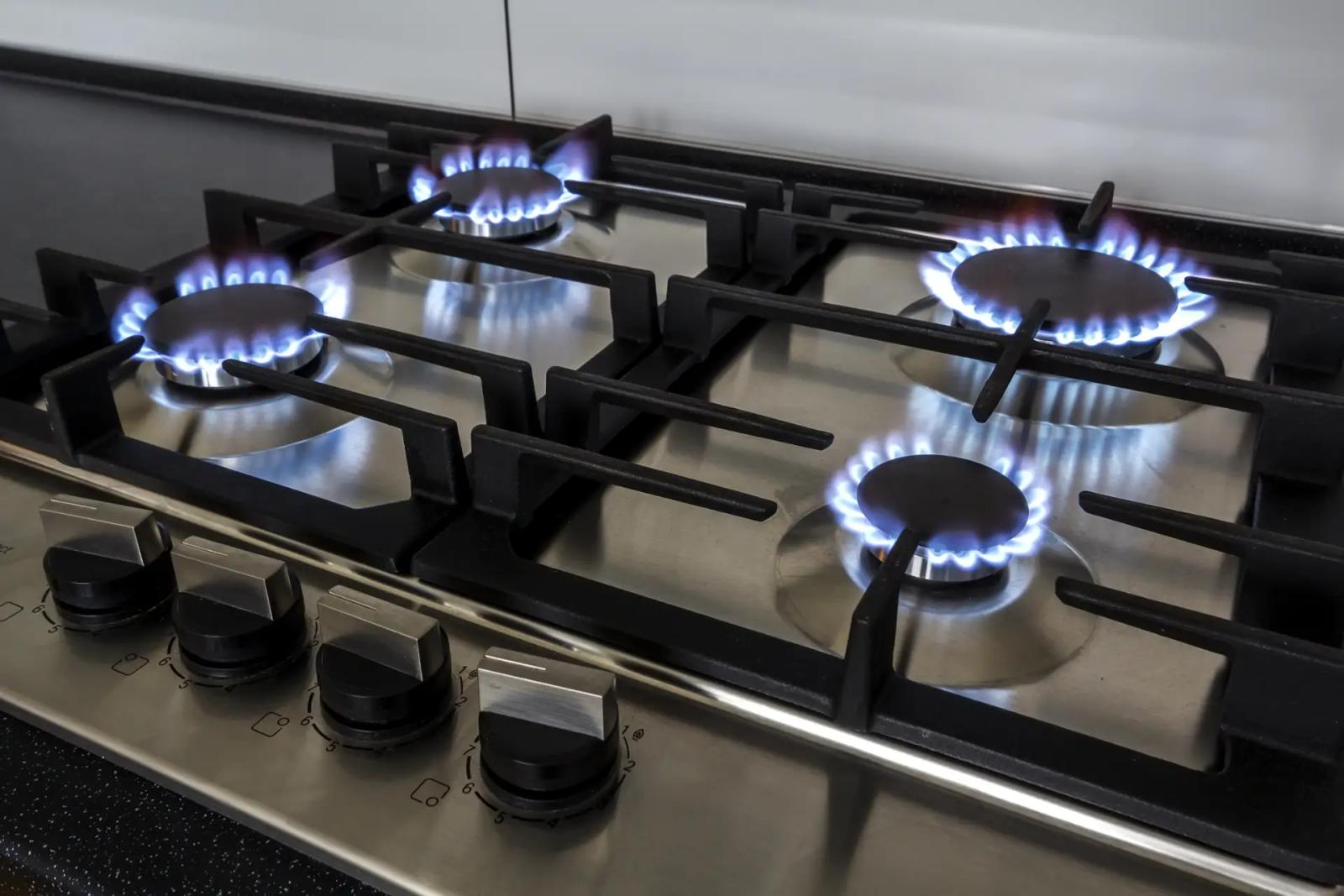 Gaskochfeld aus Edelstahl mit vier brennenden Flammen und Gusseisen-Rosten