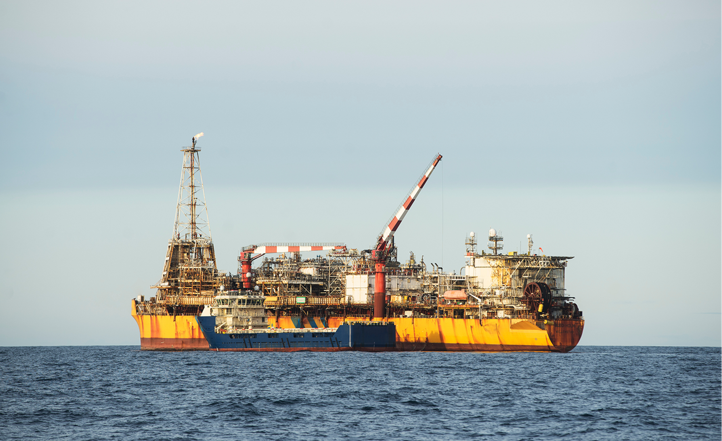 Offshore FPSO production vessel with a support boat alongside