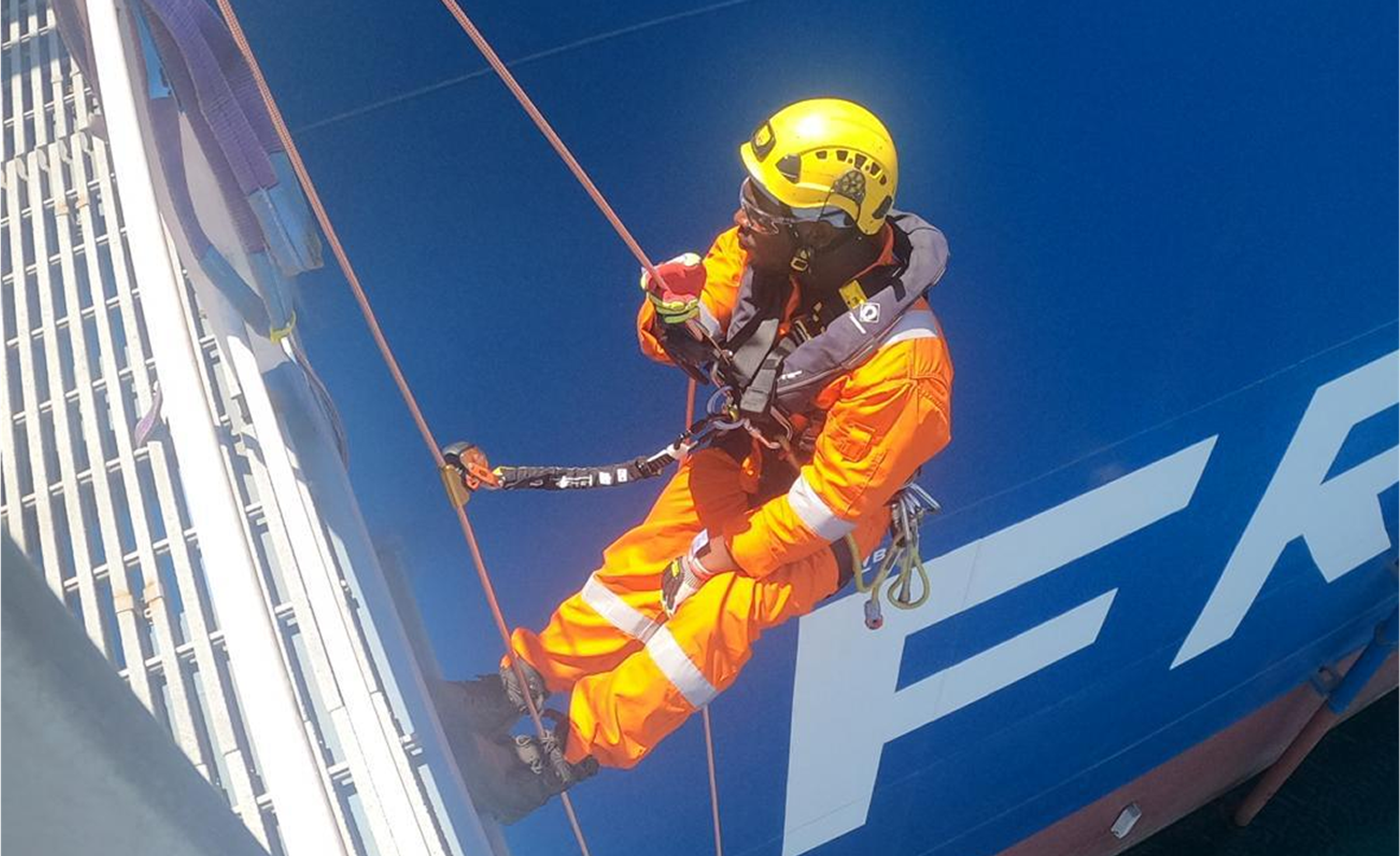 Rope access technician working at height on an industrial structure