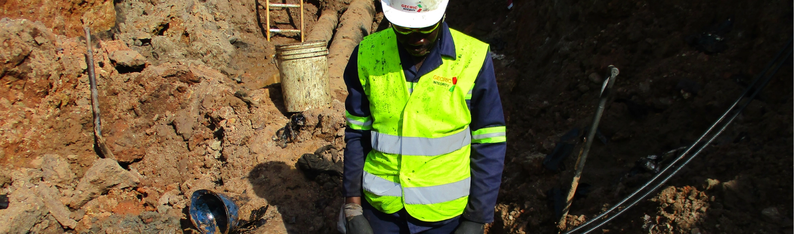 Gecric Integrity technician inspecting exposed pipelines in an excavation