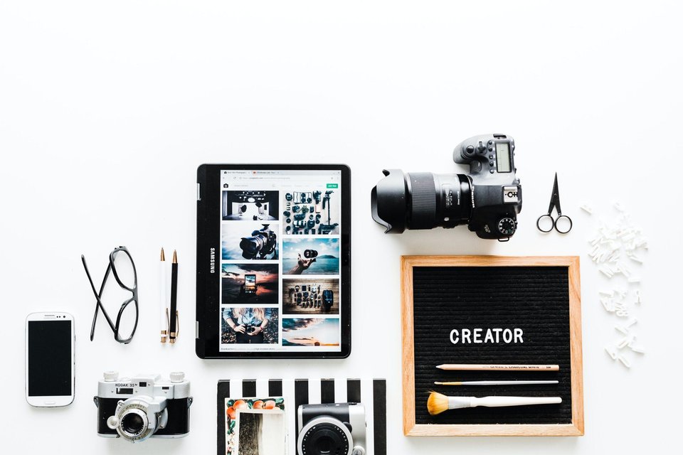 flat view of cameras beside computer tablet and smartphone|Viva Media - Toronto Video Production & Animation Studio|person writing on white paper
