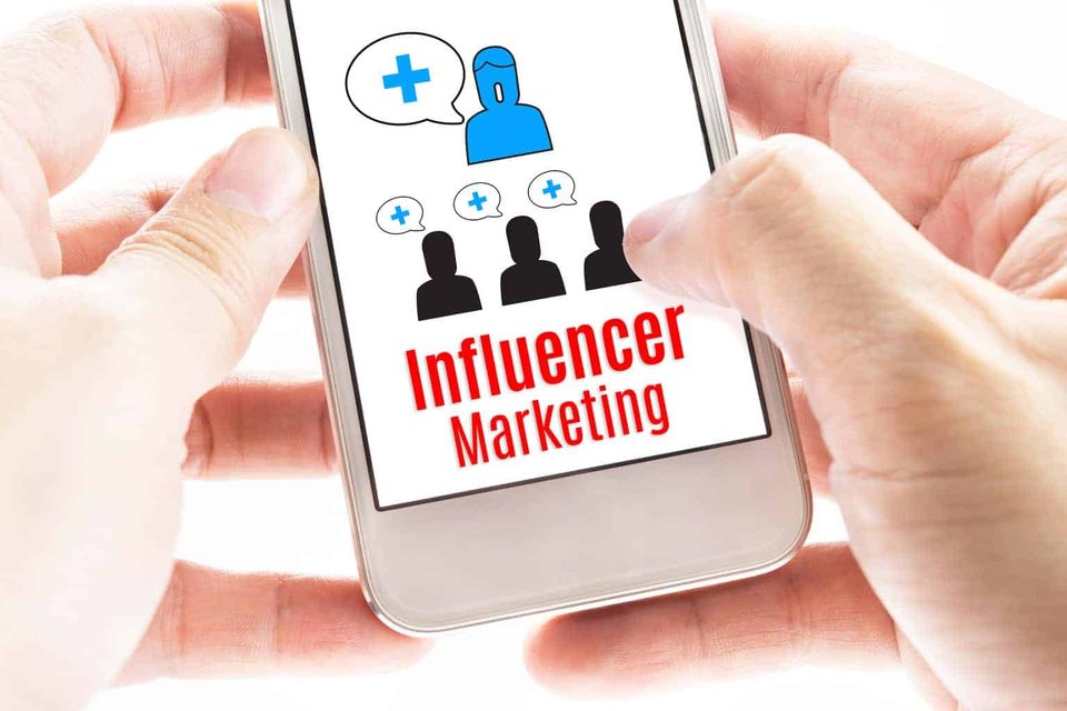 How to Create and Implement Influencer Campaigns|Two colleagues showing each other ideas