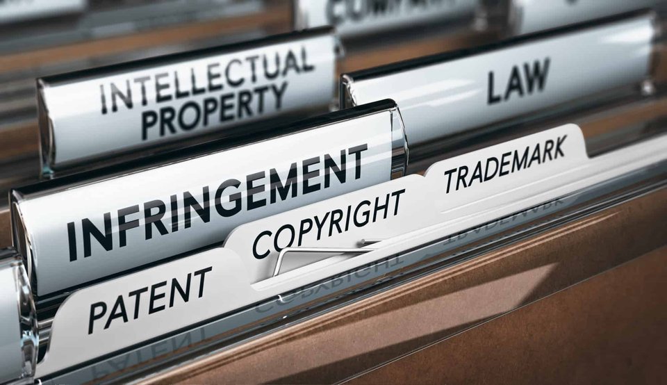 Intellectual Property Rights, Copyright, Patent or Trademark Infringement|Laptop layid on wooden office desk. Studio shot.