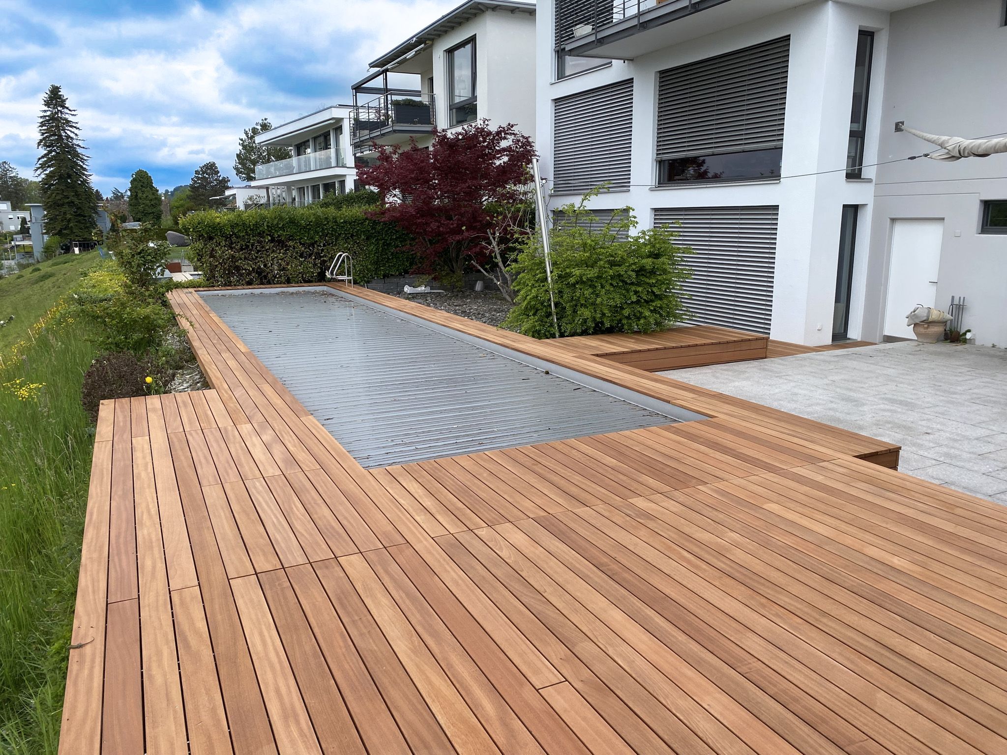 Terrassendeck aus Sipo-Holz mit integrierten Servicedeckeln