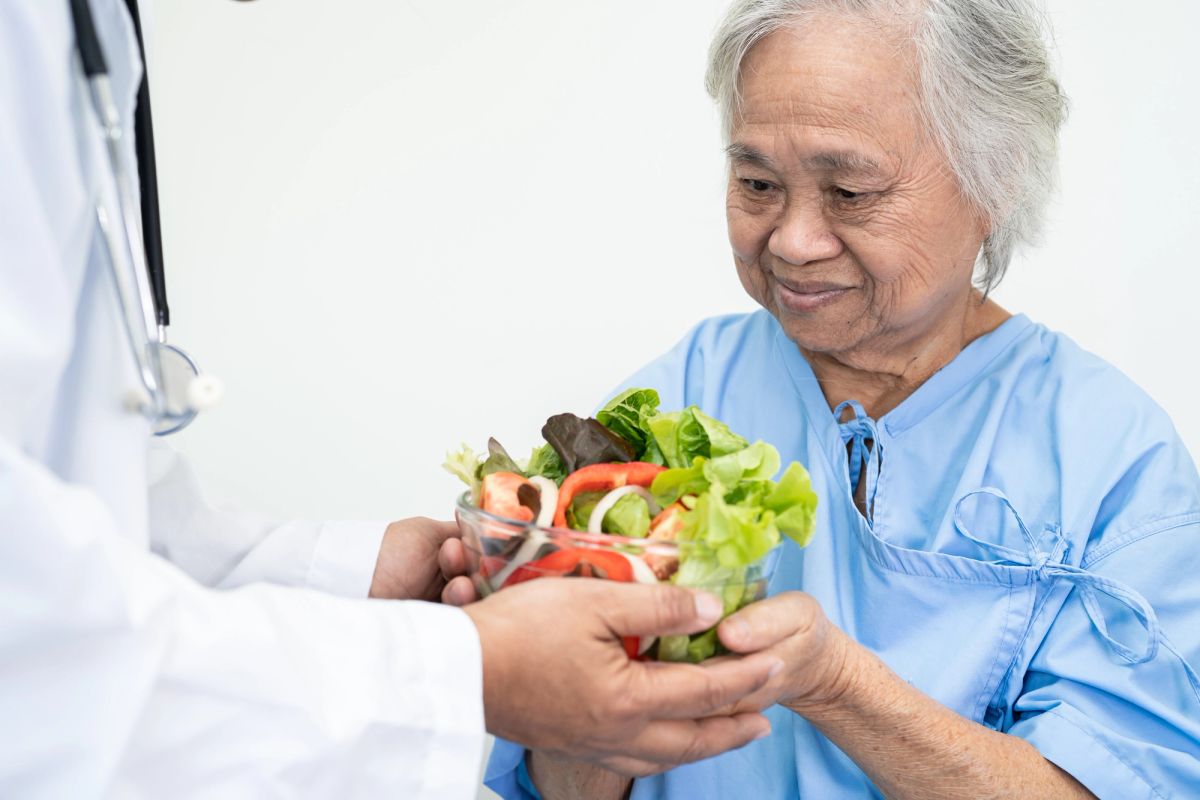 Idosa preparando refeição com acompanhamento nutricional