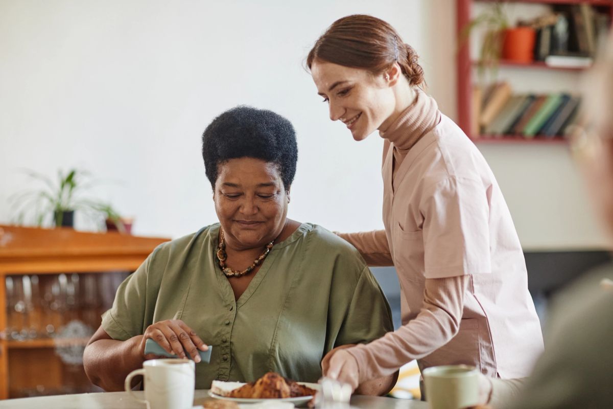 Cuidadora oferecendo refeição nutritiva ao idoso