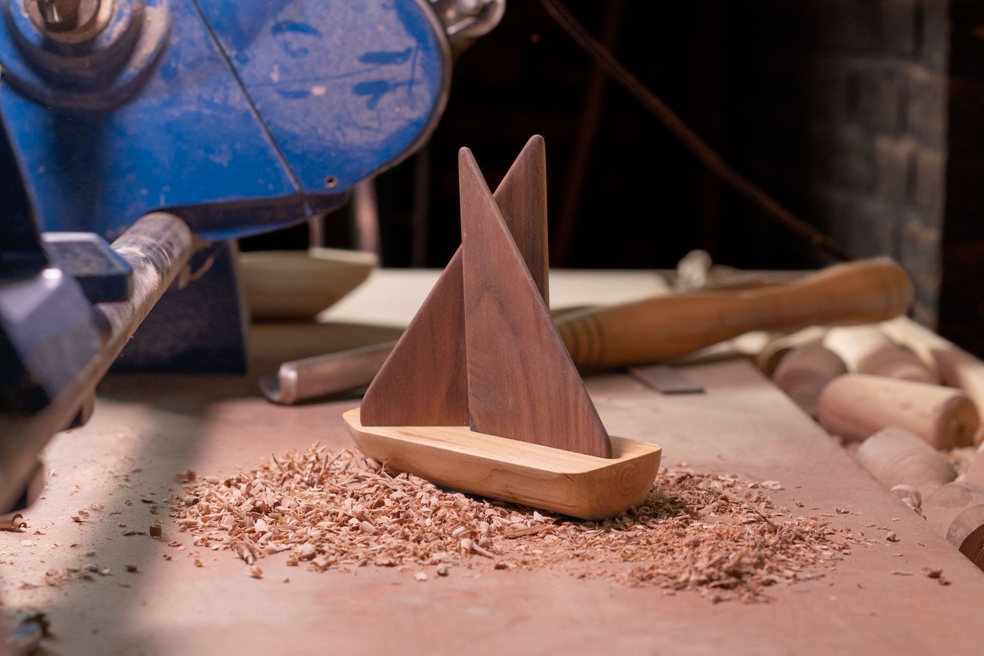 Houten boot aan draaibank met beitel op de achtergrond