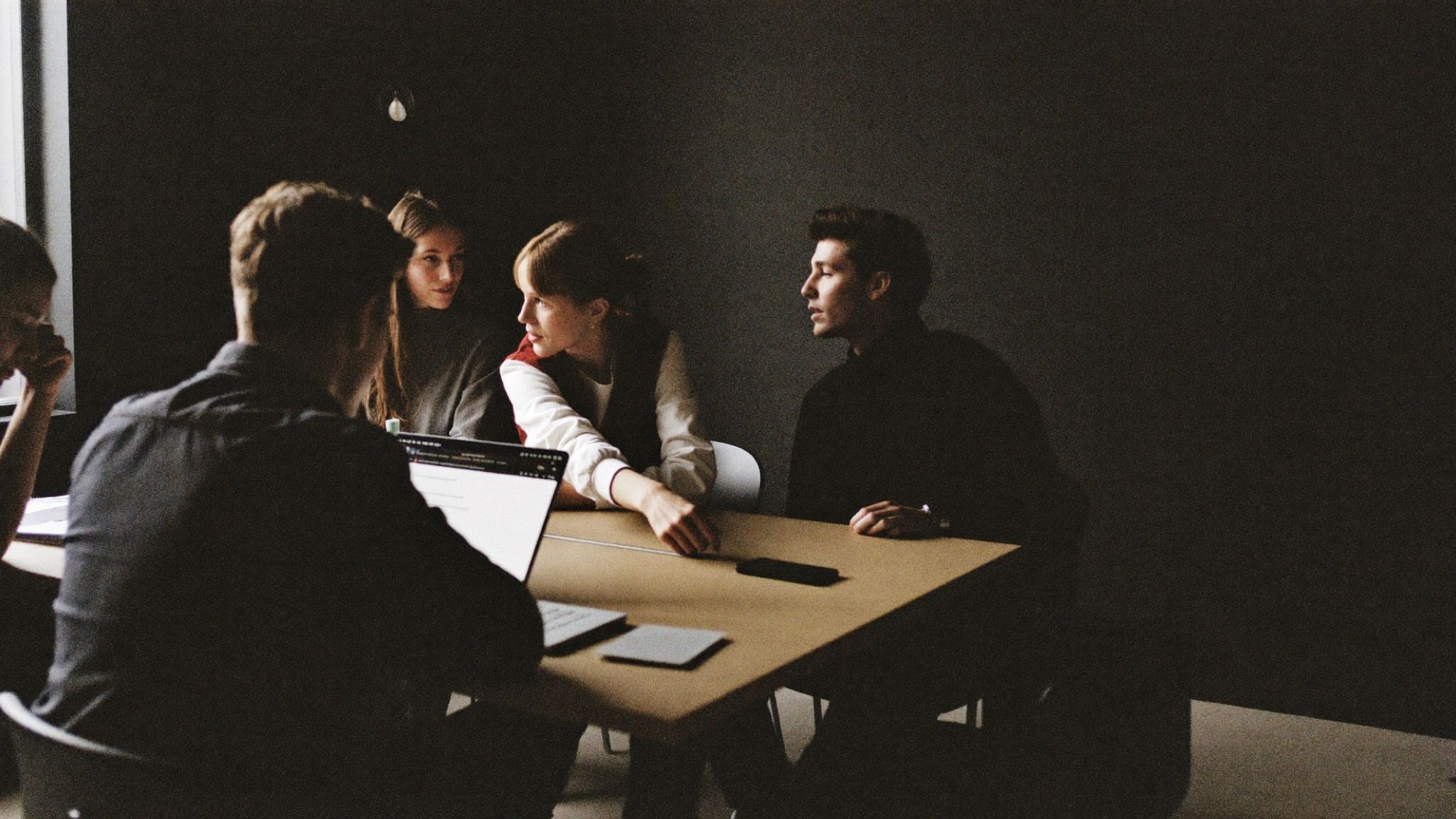 Colleagues talking around a table in a meeting room