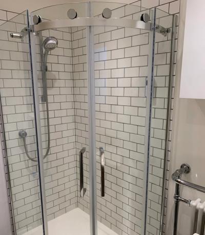 Corner shower with curved frameless doors