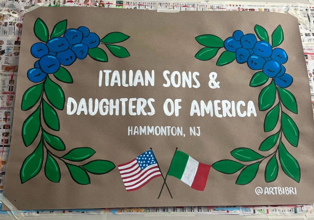 Banner reading "Italian Sons & Daughters of America, Hammonton NJ" framed by painted blueberries and leaves, with crossed Italian and American flags.